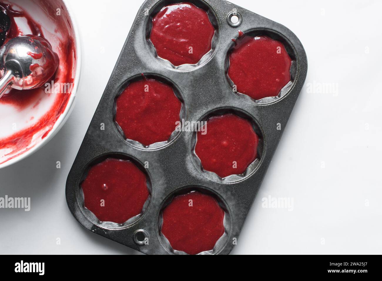 Top view of Red velvet cupcake batter in a muffin tin, scooped red velvet cake batter, process of making valentines cupcakes Stock Photo