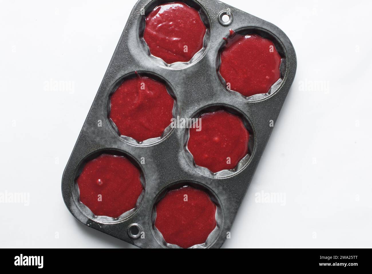 Top view of Red velvet cupcake batter in a muffin tin, scooped red velvet cake batter, process of making valentines cupcakes Stock Photo