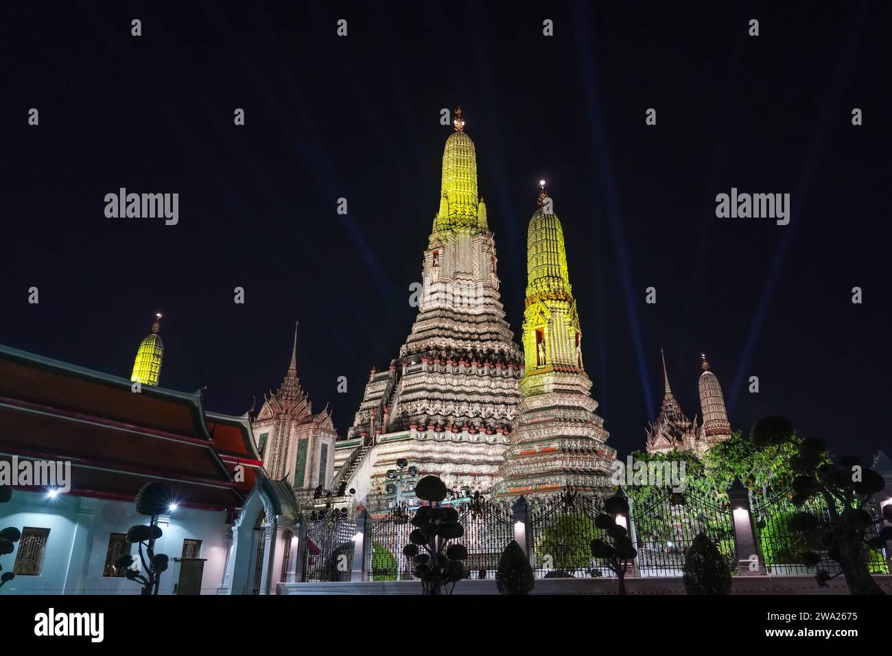 Wat Arun Ratchawararam at night illuminated by bright colored illumination. The beautiful ancient architecture Landmark of Bangkok at side of Chao Phr Stock Photo
