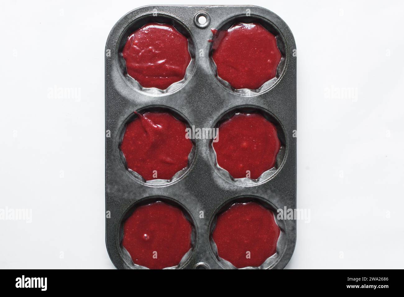 Top view of Red velvet cupcake batter in a muffin tin, scooped red velvet cake batter, process of making valentines cupcakes Stock Photo