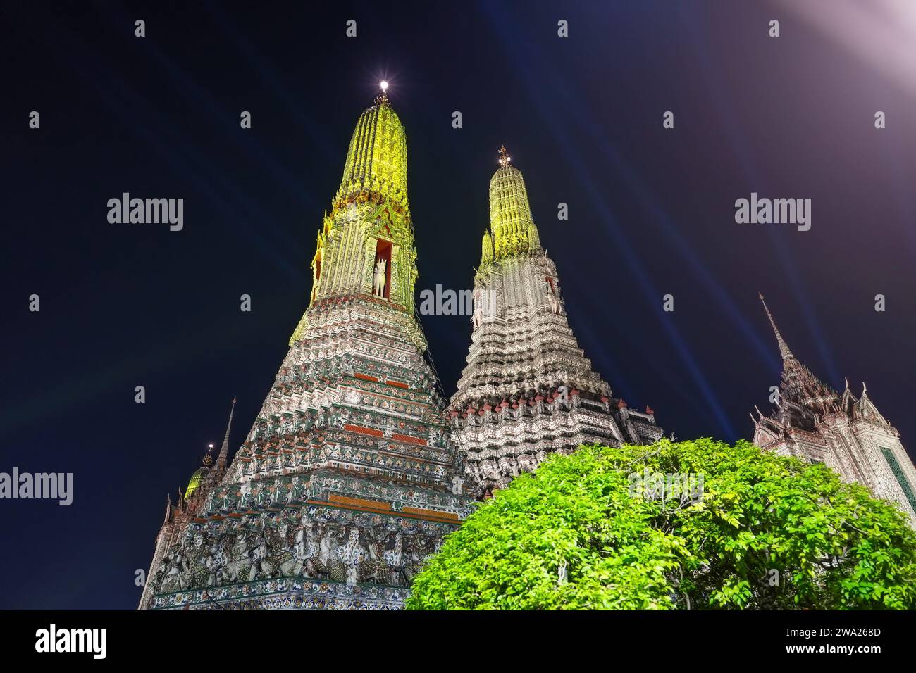 Wat Arun Ratchawararam at night illuminated by bright colored illumination. The beautiful ancient architecture Landmark of Bangkok at side of Chao Phr Stock Photo