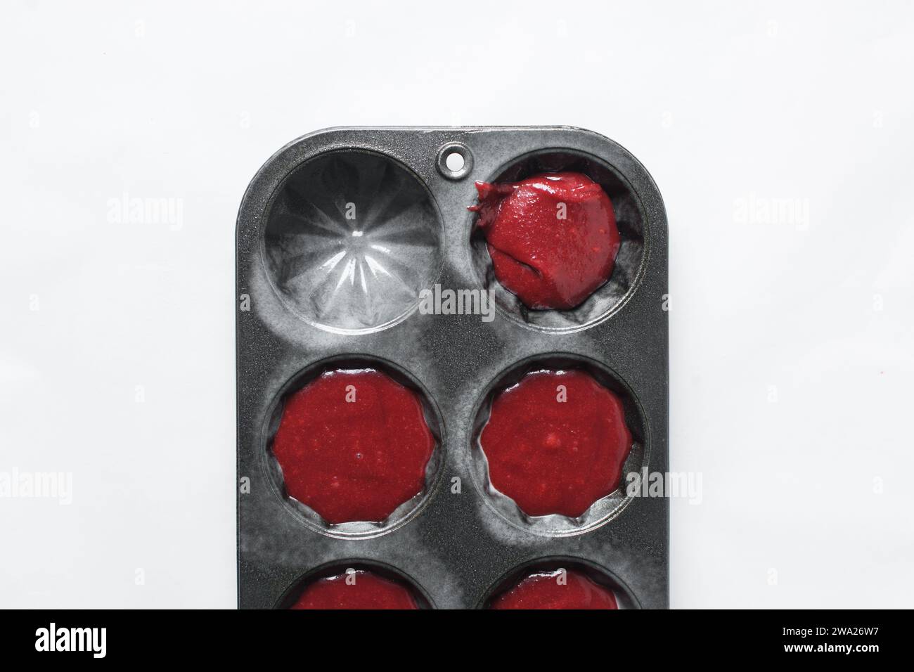 Top view of Red velvet cupcake batter in a muffin tin, scooped red velvet cake batter, process of making valentines cupcakes Stock Photo