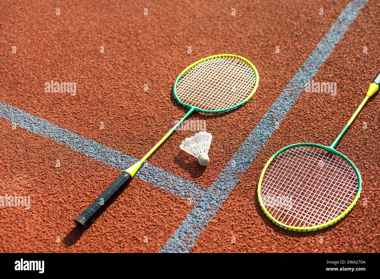 Badminton shuttlecocks and racket, placed in the corner of a synthetic