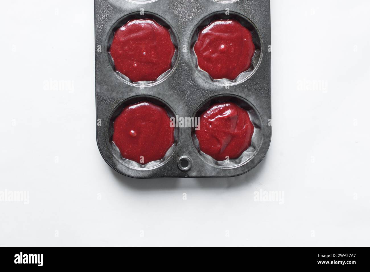 Top view of Red velvet cupcake batter in a muffin tin, scooped red velvet cake batter, process of making valentines cupcakes Stock Photo