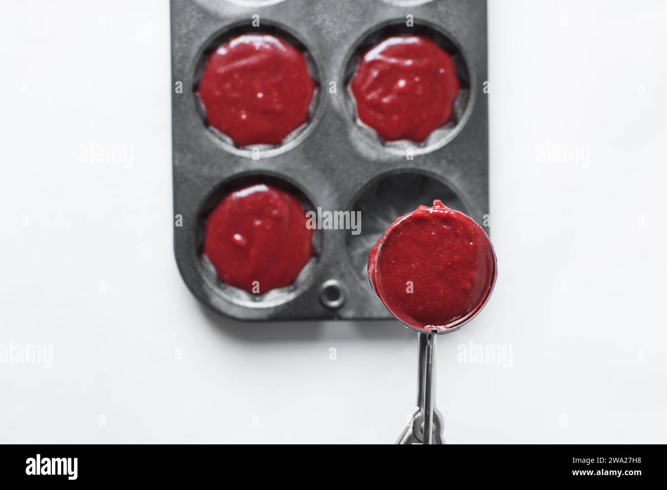 Top view of Red velvet cupcake batter in a silver scoop, scooped red velvet cake batter, process of making valentines cupcakes Stock Photo
