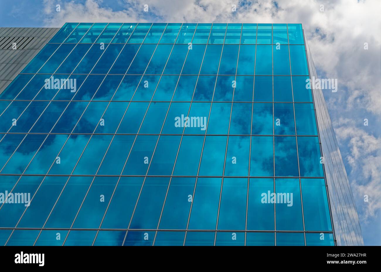 860 Washington Street, a parallelogram-shaped blue glass box, reflects sky and adjacent buildings next to the High Line in the Meatpacking District. Stock Photo