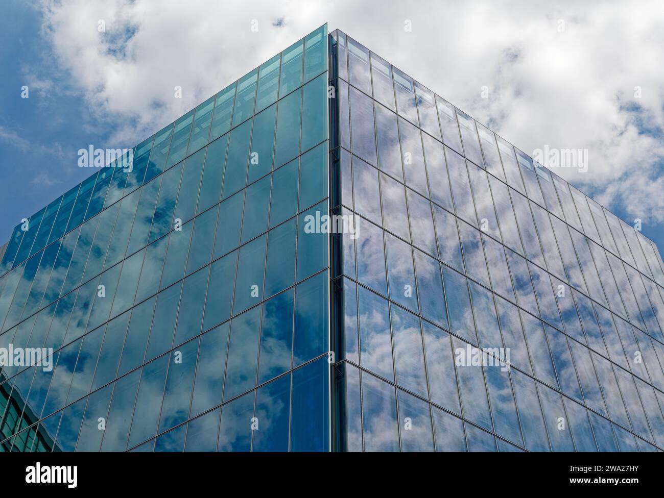 860 Washington Street, a parallelogram-shaped blue glass box, reflects sky and adjacent buildings next to the High Line in the Meatpacking District. Stock Photo