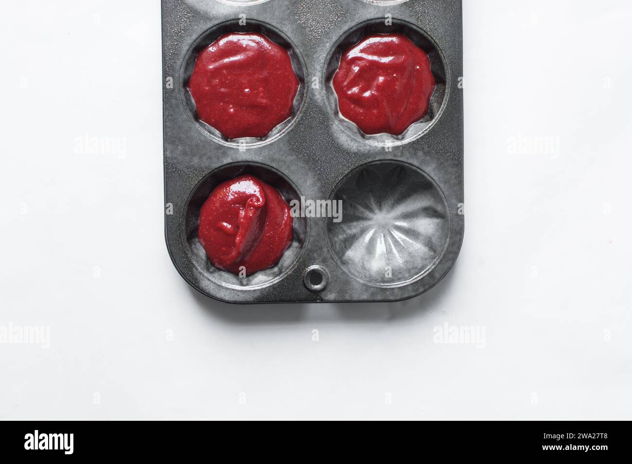 Top view of Red velvet cupcake batter in a muffin tin, scooped red velvet cake batter, process of making valentines cupcakes Stock Photo