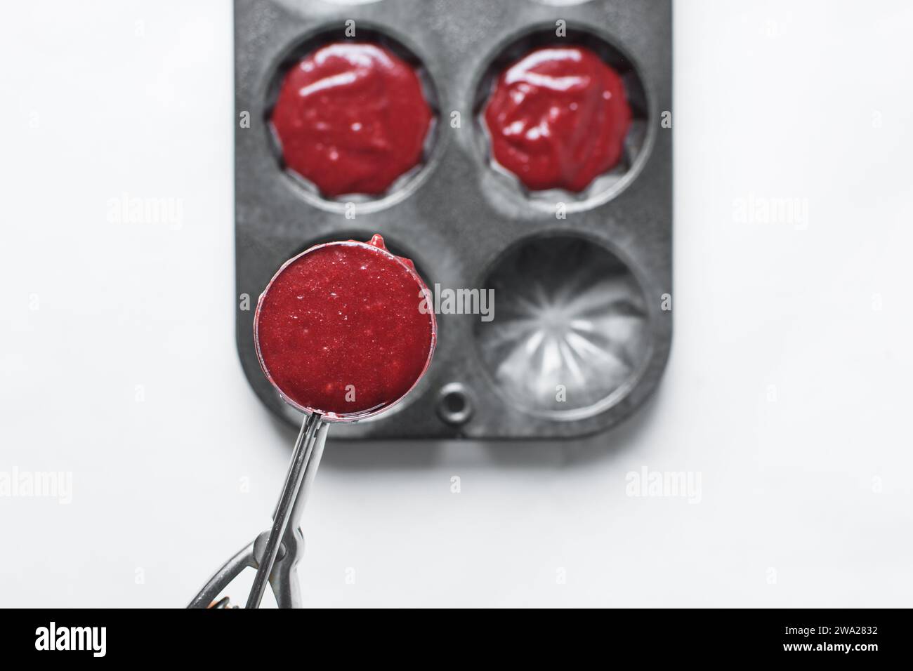Top view of Red velvet cupcake batter in a silver scoop, scooped red velvet cake batter, process of making valentines cupcakes Stock Photo