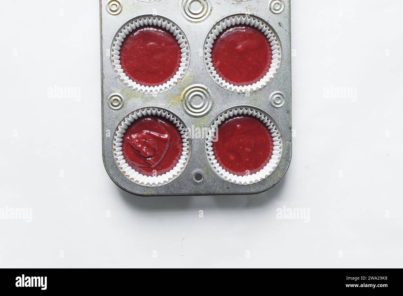 Top view of Red velvet cupcake batter in a muffin tin, scooped red velvet cake batter, process of making valentines cupcakes Stock Photo
