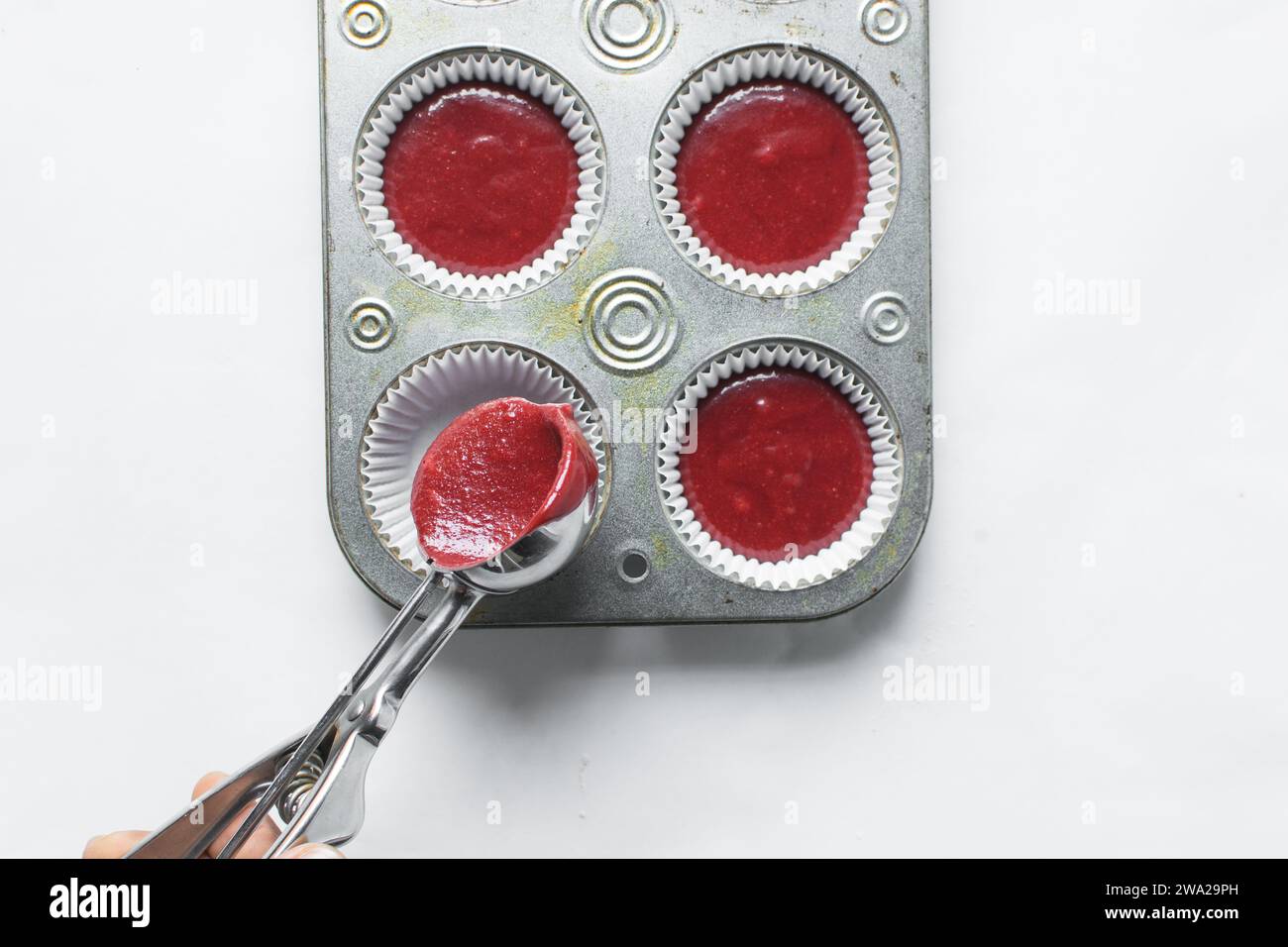 Top view of Red velvet cupcake batter in a silver scoop, scooped red velvet cake batter, process of making valentines cupcakes Stock Photo