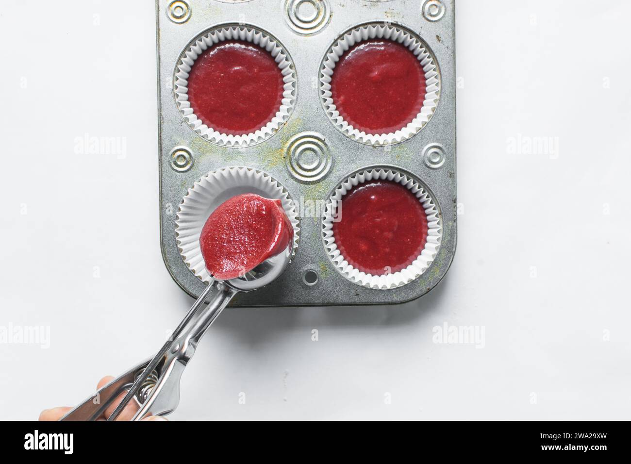 Top view of Red velvet cupcake batter in a silver scoop, scooped red velvet cake batter, process of making valentines cupcakes Stock Photo