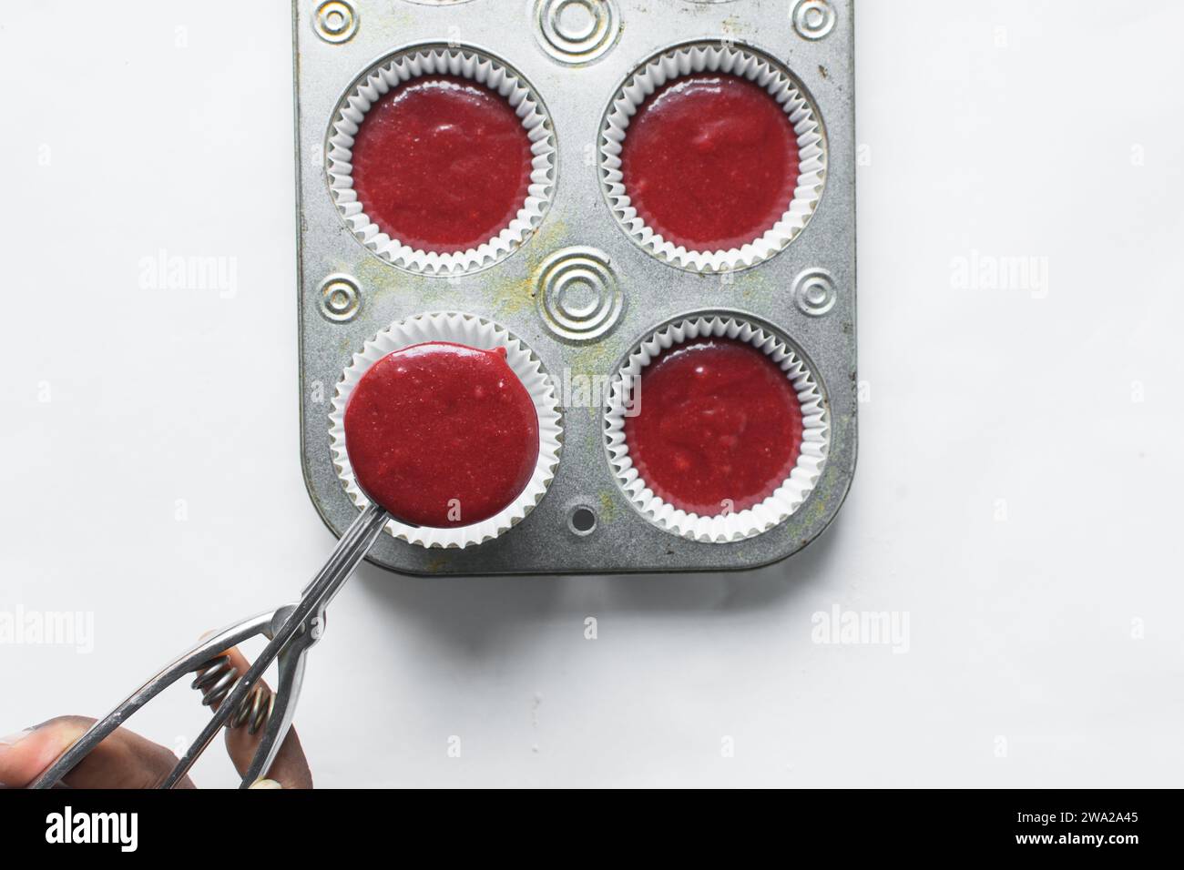 Top view of Red velvet cupcake batter in a silver scoop, scooped red velvet cake batter, process of making valentines cupcakes Stock Photo