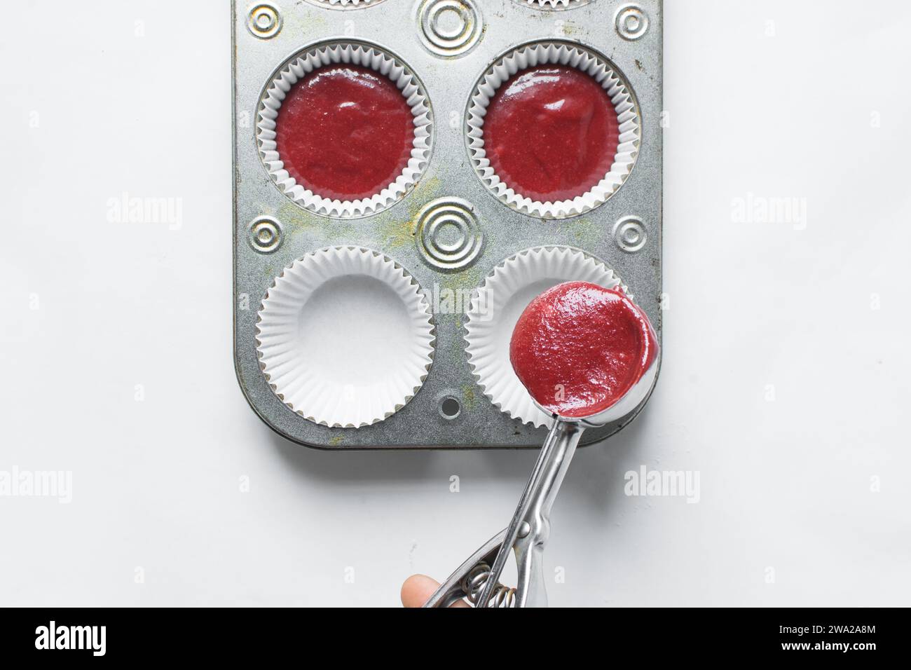 Top view of Red velvet cupcake batter in a silver scoop, scooped red velvet cake batter, process of making valentines cupcakes Stock Photo