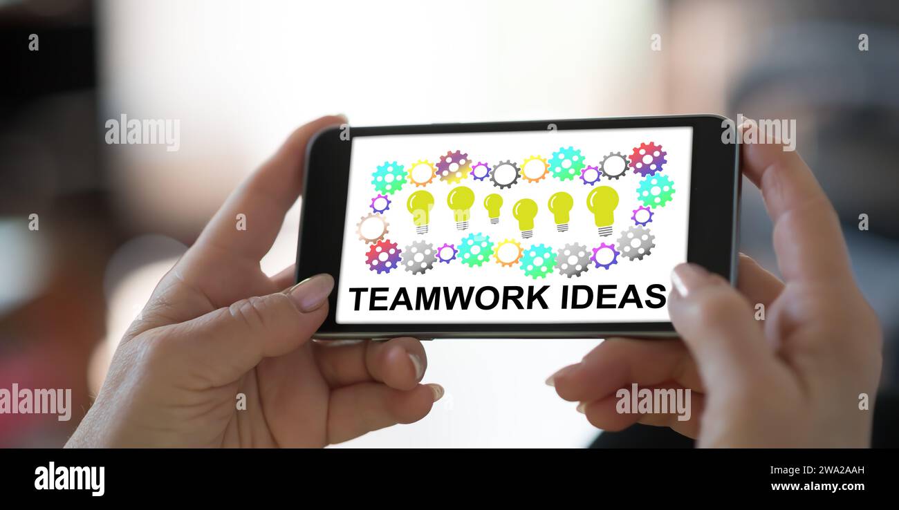 Hand holding a smartphone with teamwork idea concept Stock Photo - Alamy