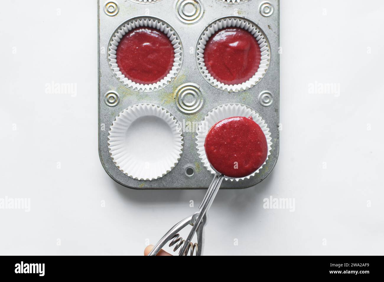 Top view of Red velvet cupcake batter in a silver scoop, scooped red velvet cake batter, process of making valentines cupcakes Stock Photo