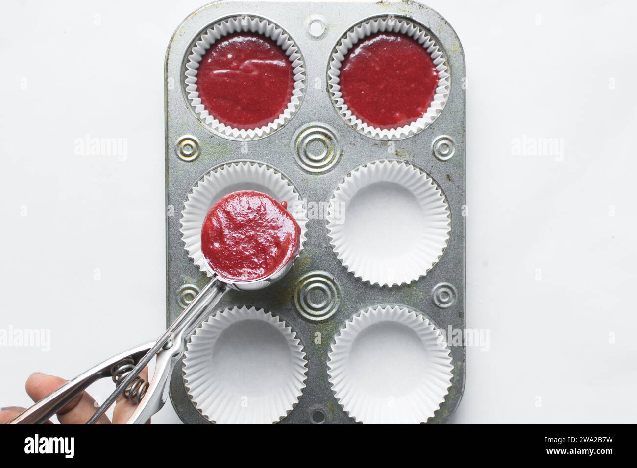 Top view of Red velvet cupcake batter in a silver scoop, scooped red velvet cake batter, process of making valentines cupcakes Stock Photo