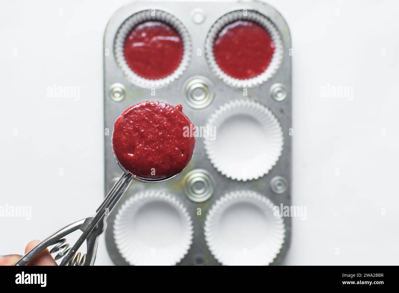Top view of Red velvet cupcake batter in a silver scoop, scooped red velvet cake batter, process of making valentines cupcakes Stock Photo