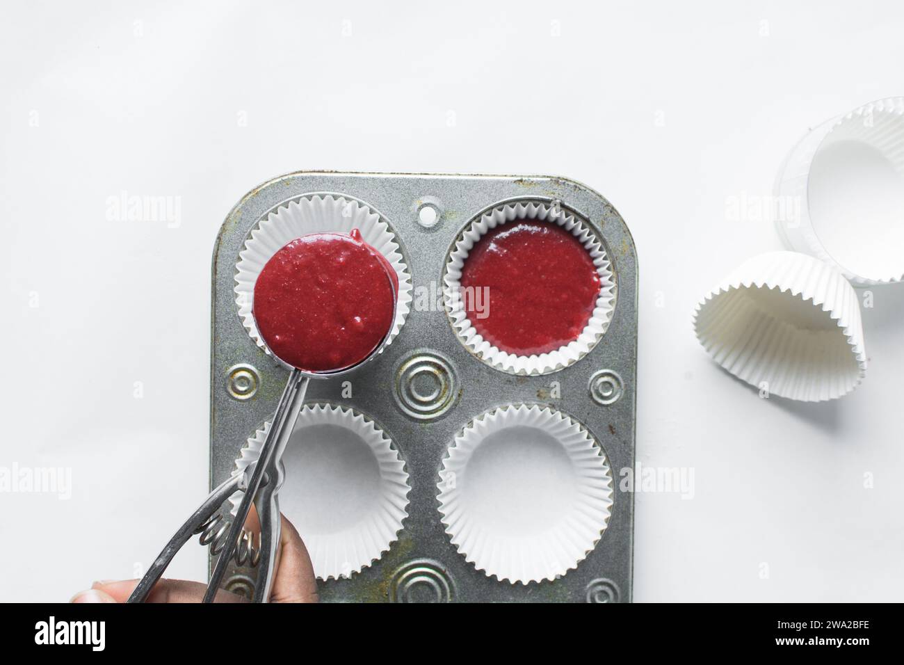 Top view of Red velvet cupcake batter in a silver scoop, scooped red velvet cake batter, process of making valentines cupcakes Stock Photo