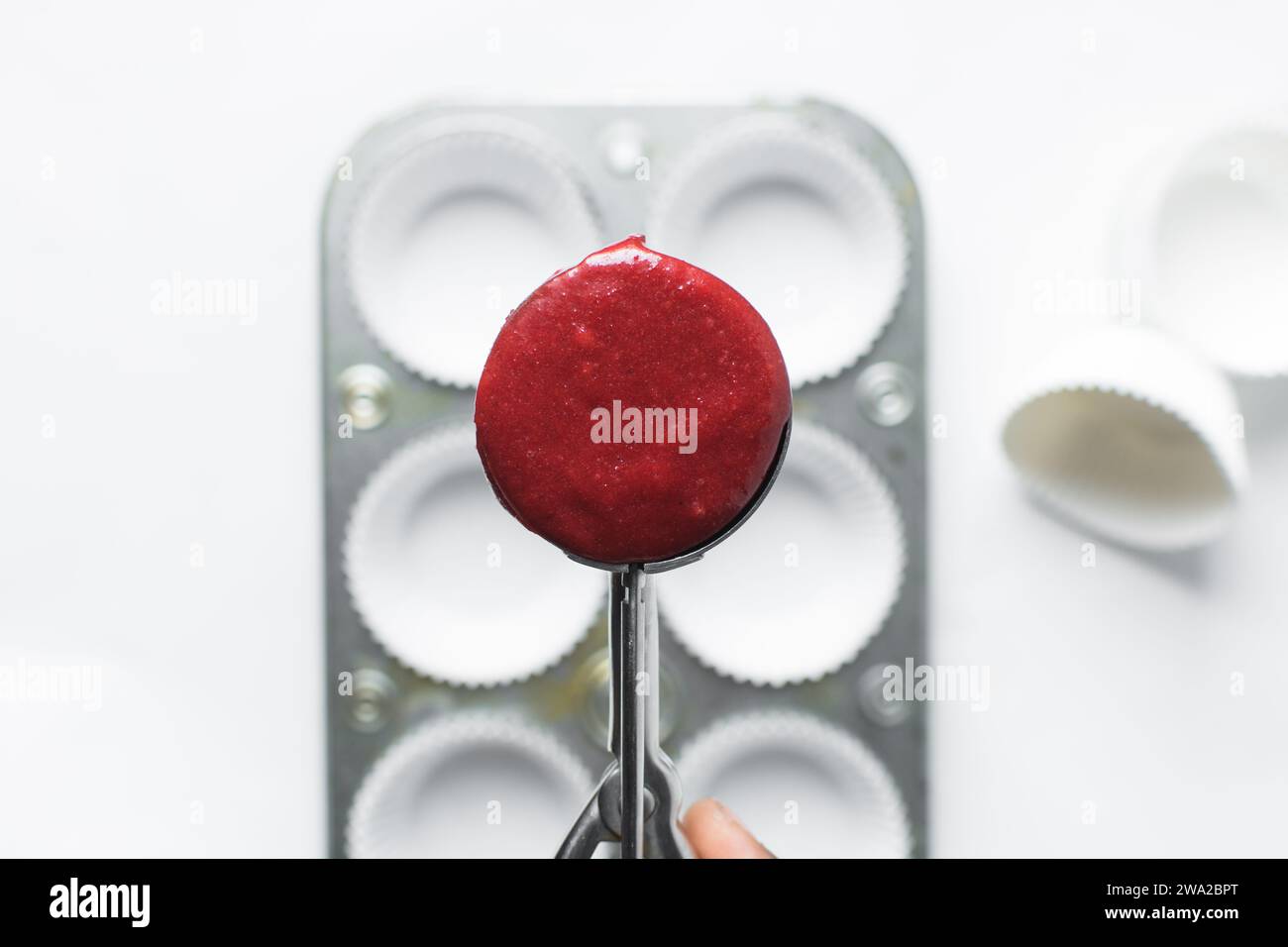 Top view of Red velvet cupcake batter in a silver scoop, scooped red velvet cake batter, process of making valentines cupcakes Stock Photo