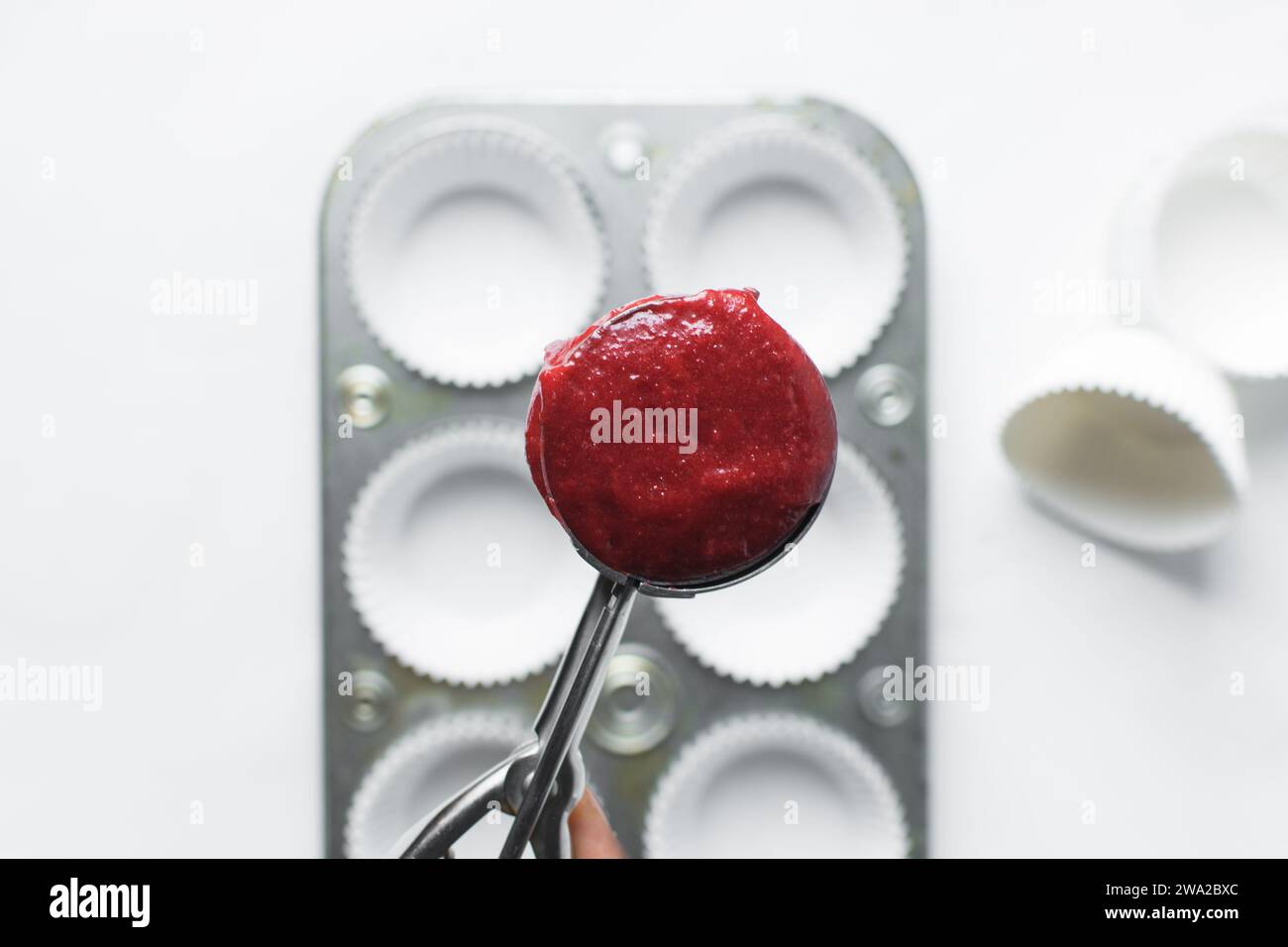 Top view of Red velvet cupcake batter in a silver scoop, scooped red velvet cake batter, process of making valentines cupcakes Stock Photo
