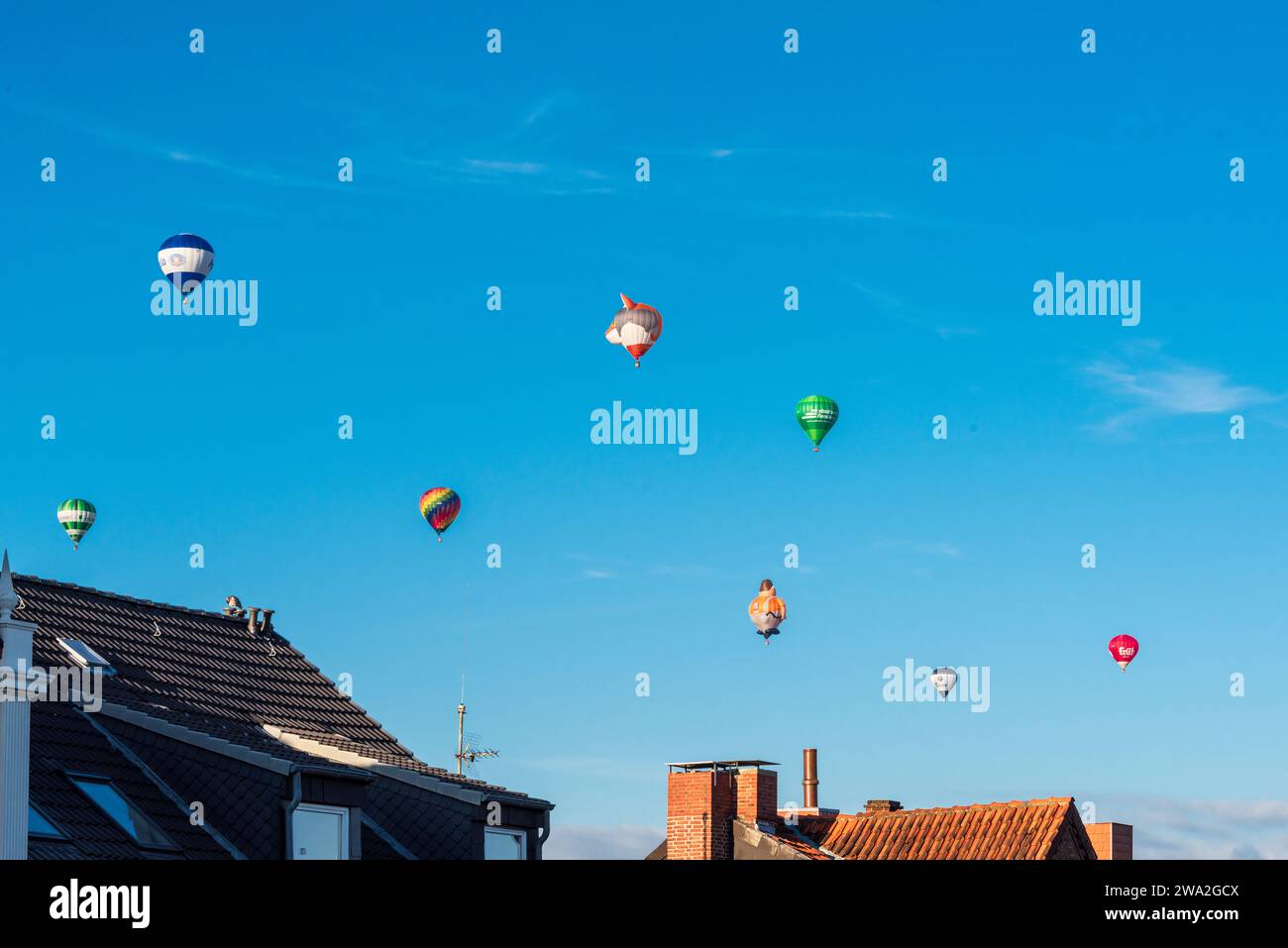 Bunte Heißluftballons über den Dächern der Kieler Altstadt vor blauem Himmel im Sommer Stock Photo