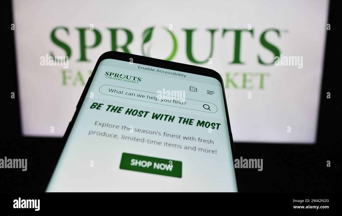 Smartphone with website of US retail company Sprouts Farmers Market Inc. in front of business logo. Focus on top-left of phone display. Stock Photo