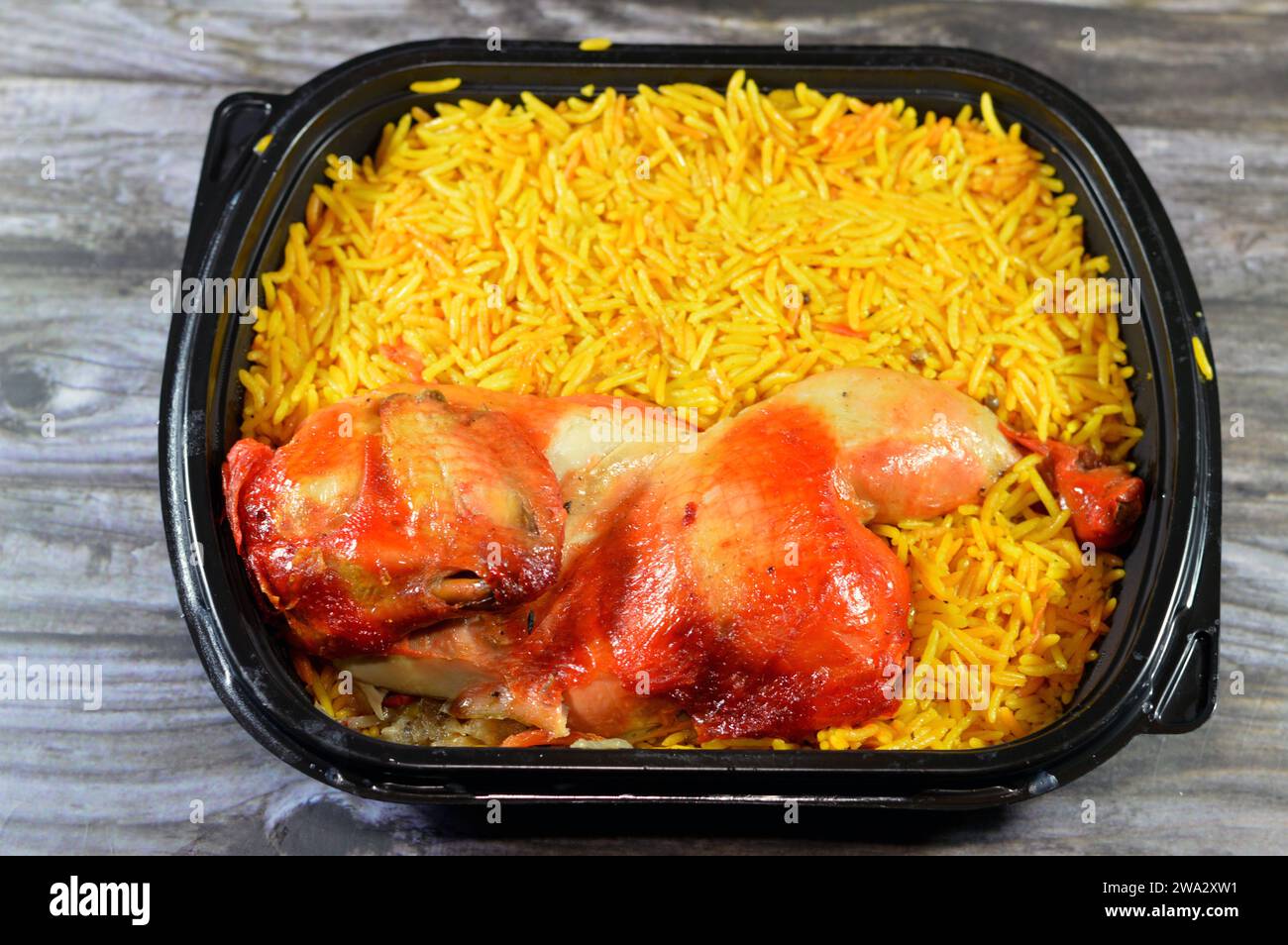 Chicken mandi kabsa with long basmati rice, usually served with tomato dakos sauce, green salad and tahini, Yemen recipe of Yemeni Mandi chicken and r Stock Photo