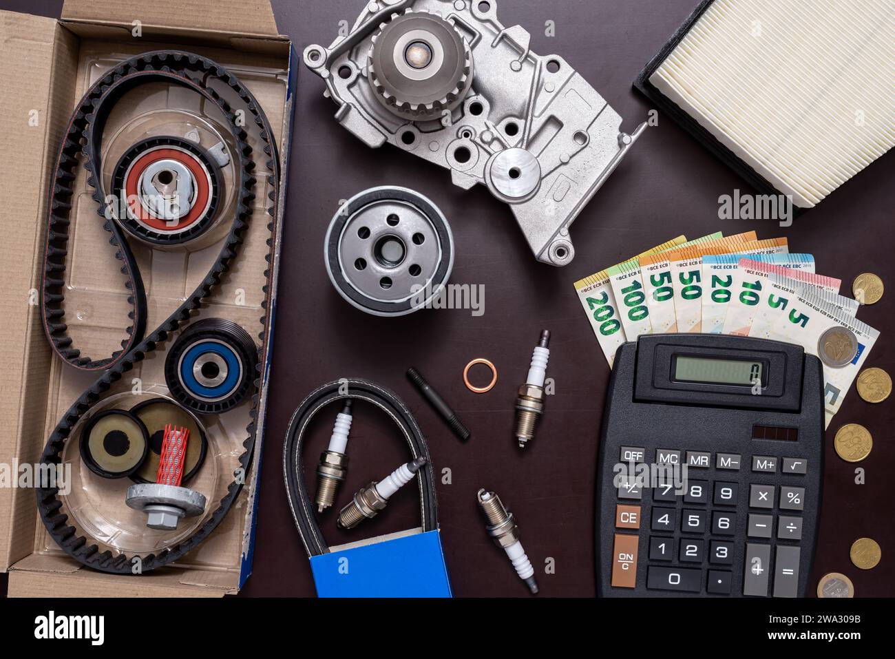 Spare parts for car repair, calculator and money on the working table. Stock Photo