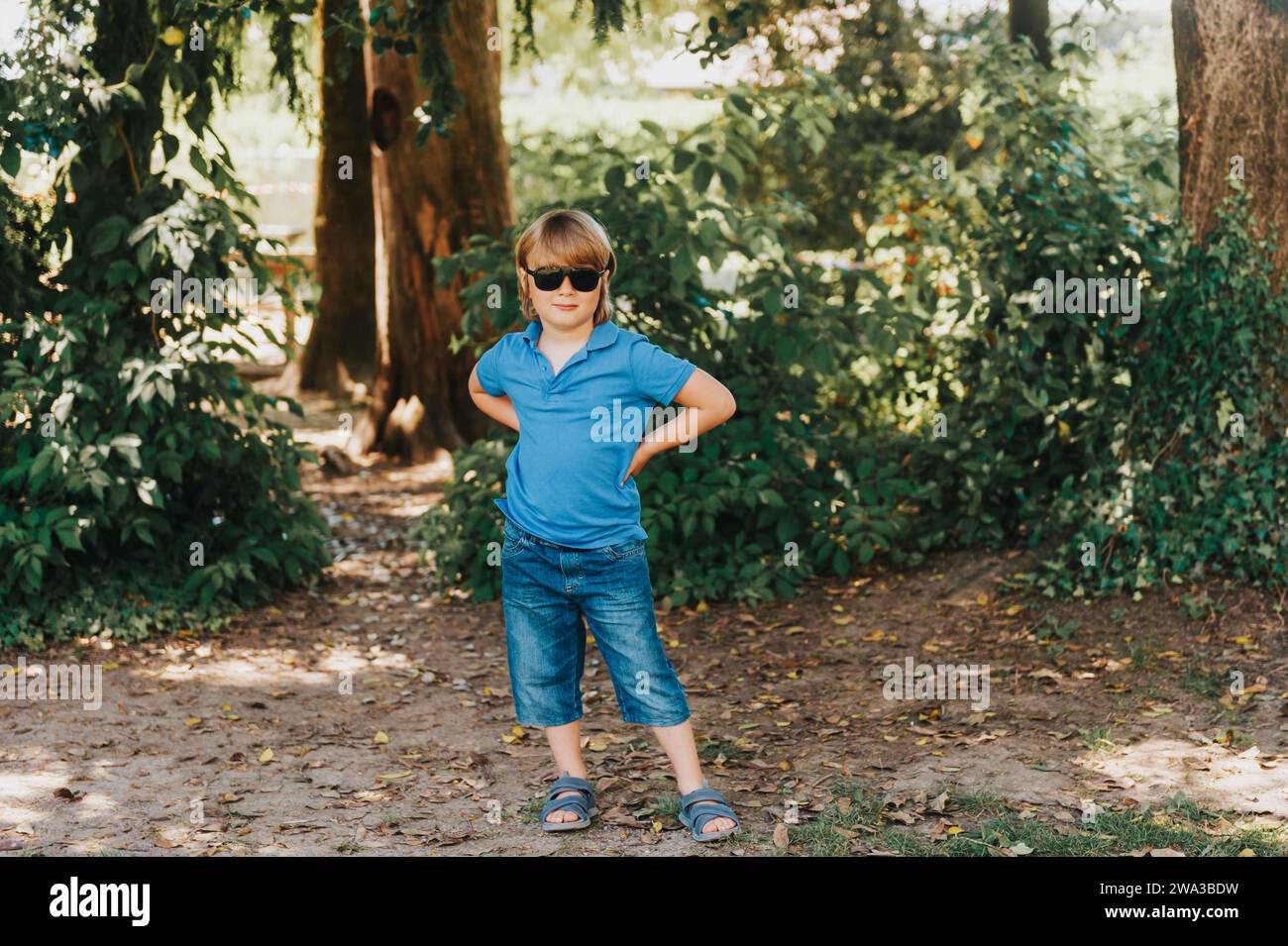 Outdoor portrait of adorable little boy wearing blue polo and fashion sunglasses Stock Photo