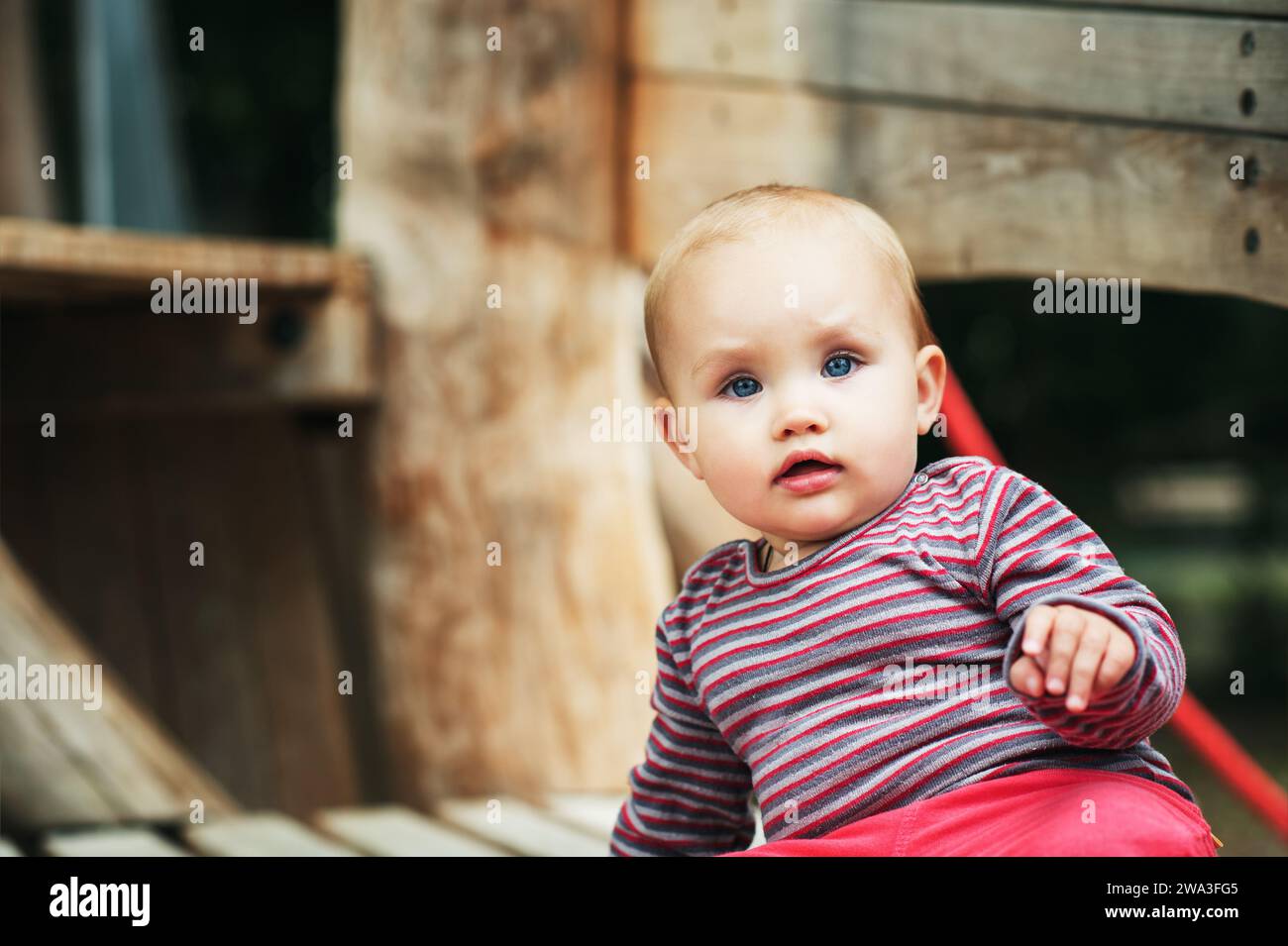 Outdoor portrait of adorable baby girl having fun on playground Stock Photo