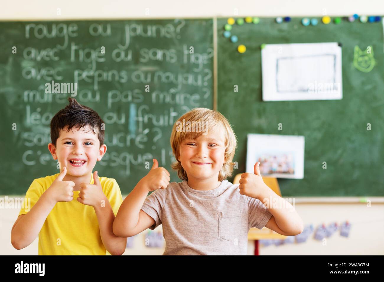 Happy children working in classroom, big thumbs up, education, back to school concept Stock Photo