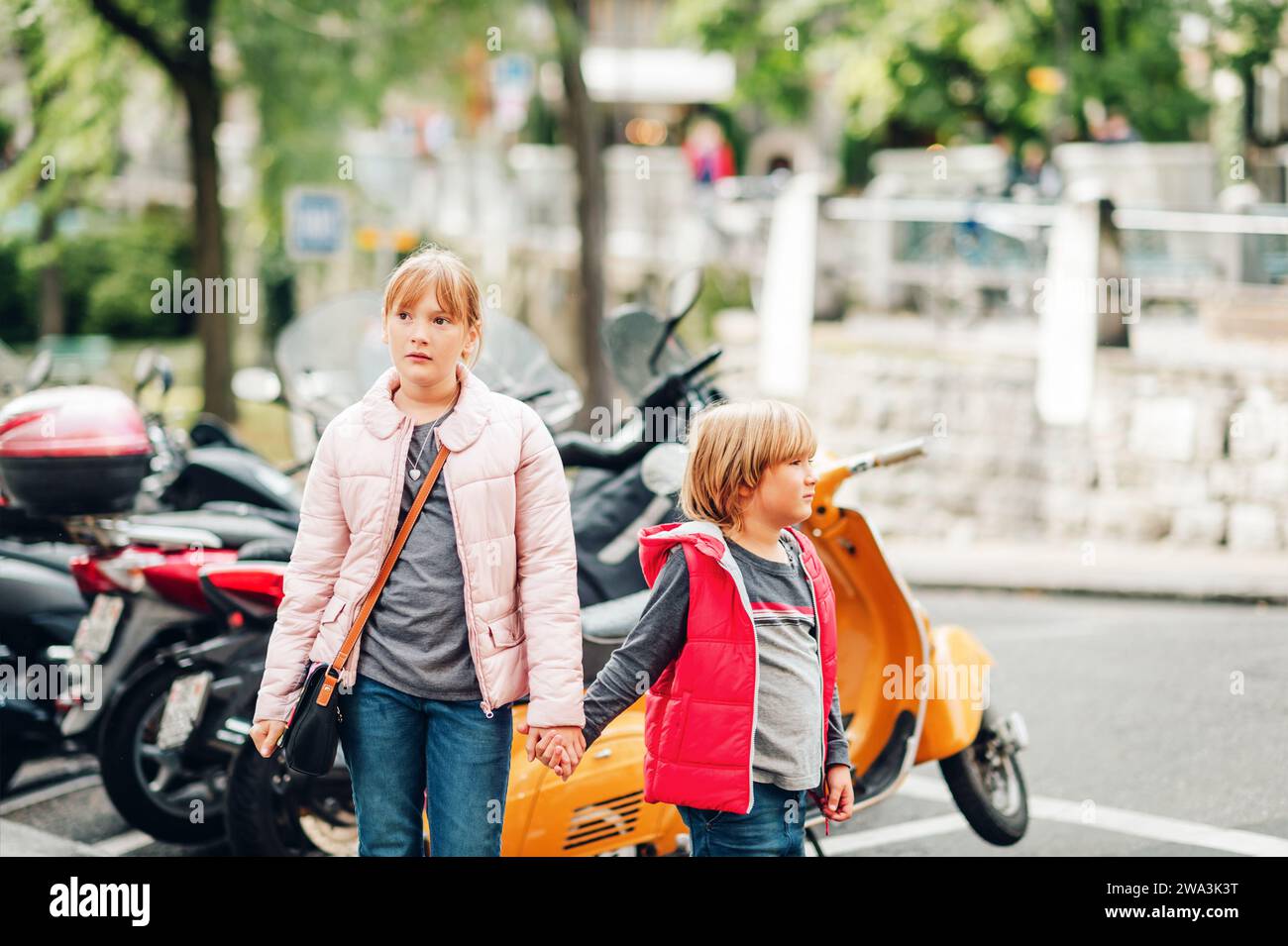 Street fashion for children. Boy and girl wearing padded jackets. Little brother and sister spending time together Stock Photo