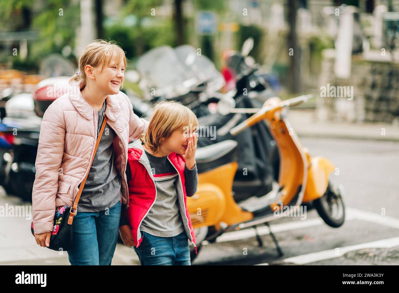 Street fashion for children. Boy and girl wearing padded jackets. Little brother and sister spending time together Stock Photo