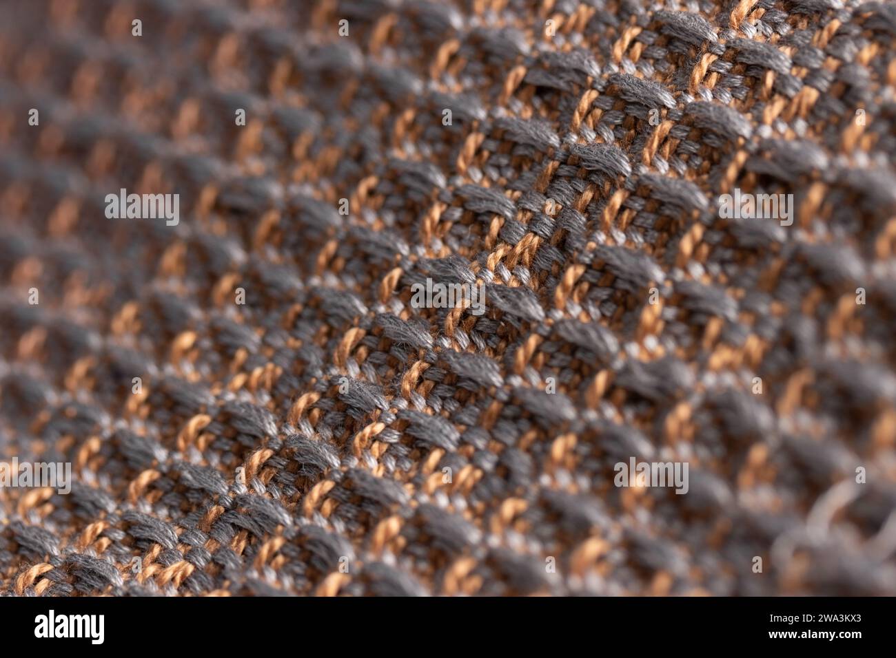 draped fabric woven using waffle weave technique in brown and gray, close up detail macro shot with shallow depth of field Stock Photo
