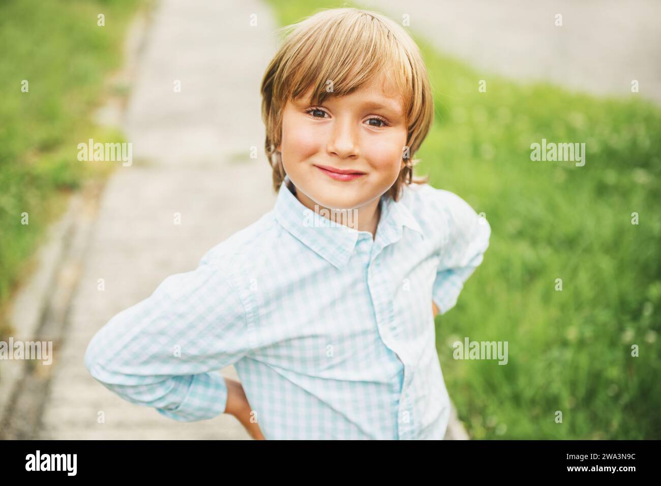Outdoor portrait of adorable 6 year old boy wearing blue shirt Stock Photo Alamy