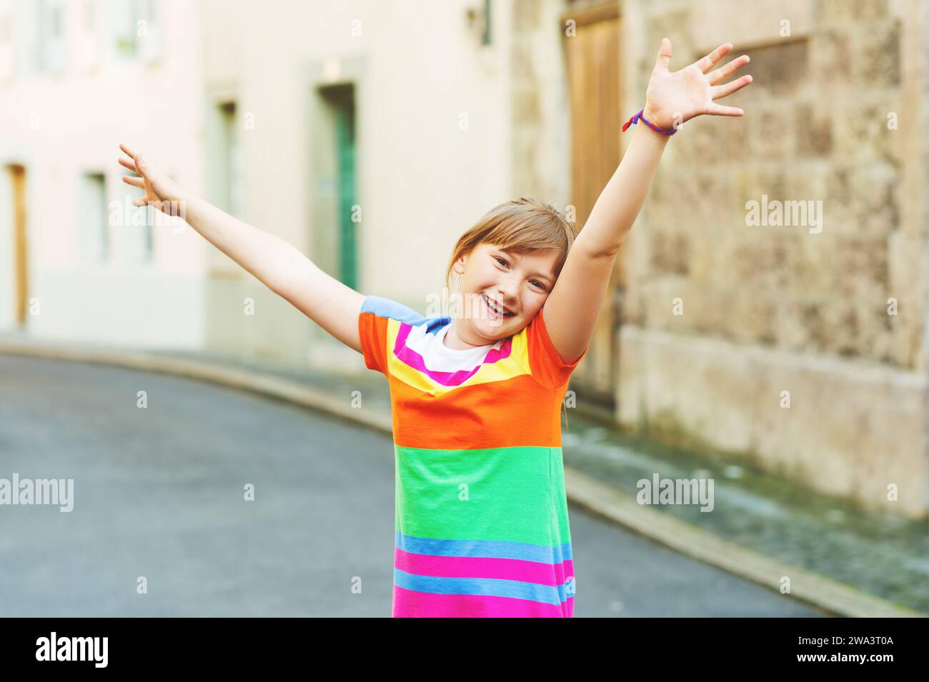 Happy smiling joyful kid girl with arms up playing on the street Stock ...