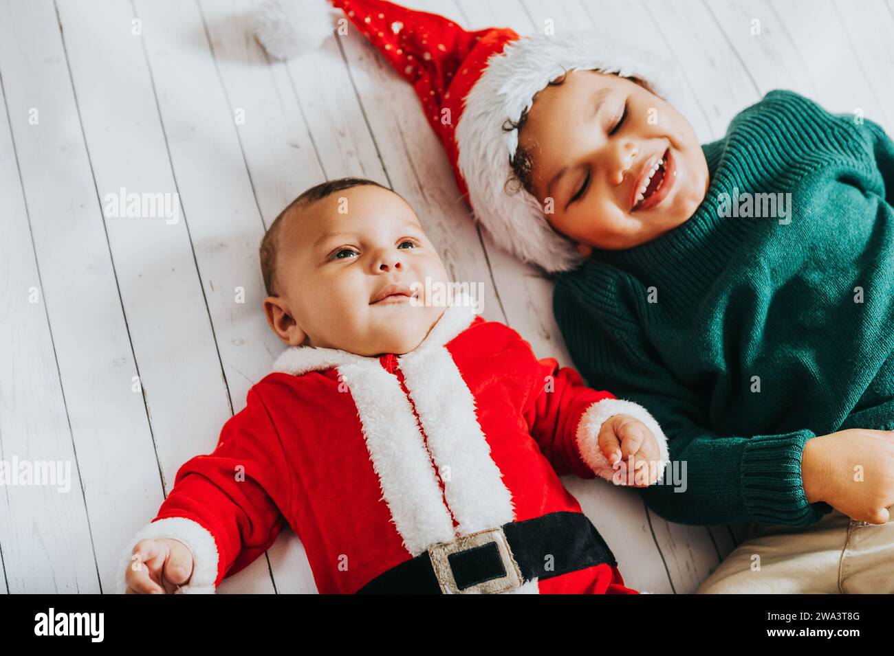 Image of two funny boys wearing christmas outfit, top view Stock Photo