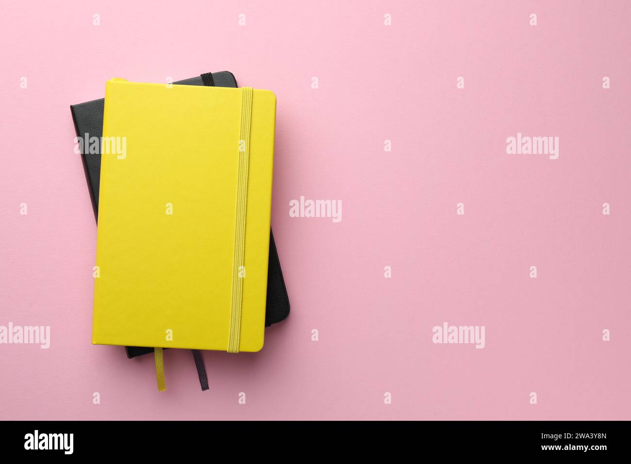Different notebooks on light pink background, top view. Space for text Stock Photo