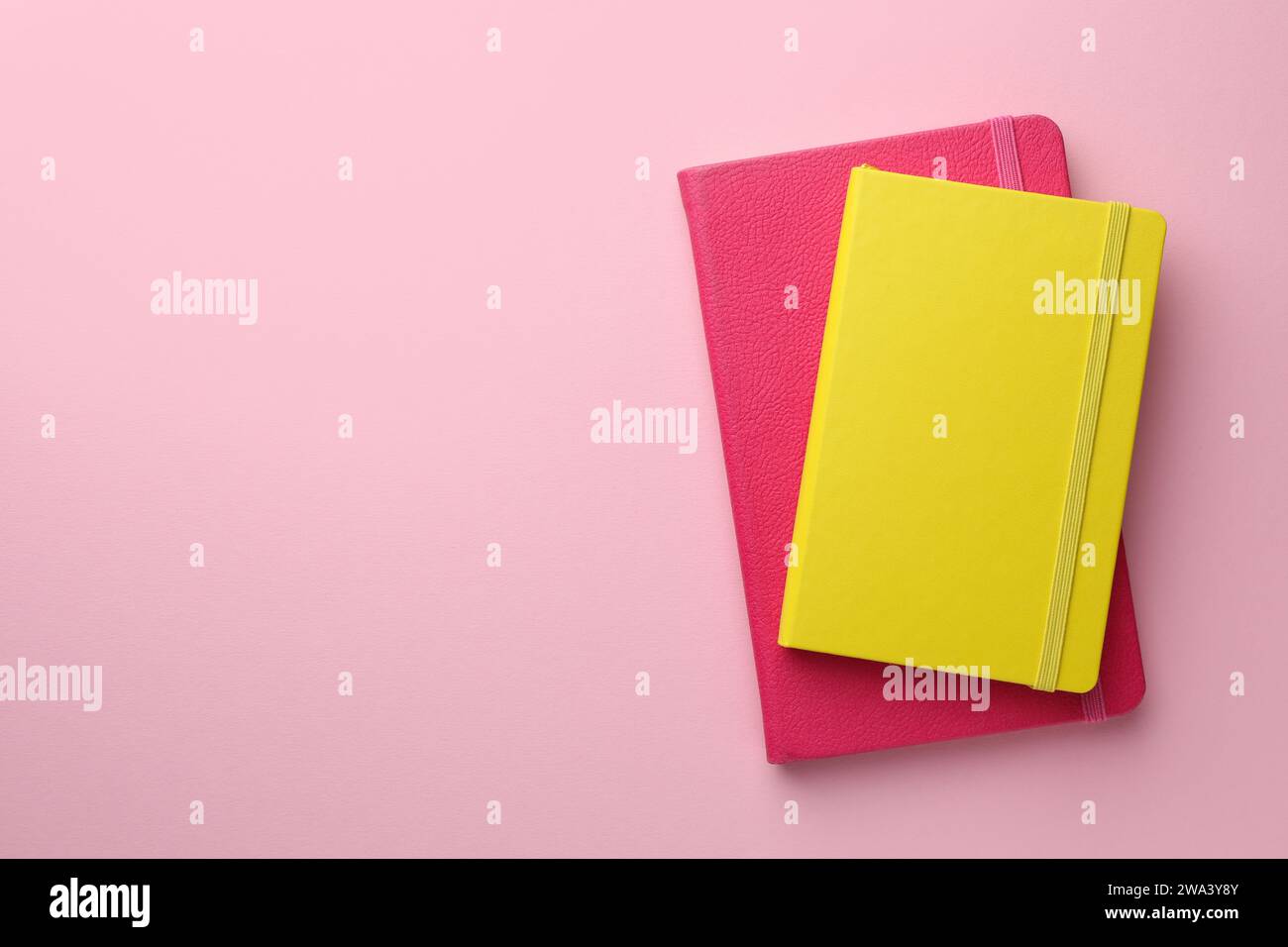 Different notebooks on light pink background, top view. Space for text Stock Photo