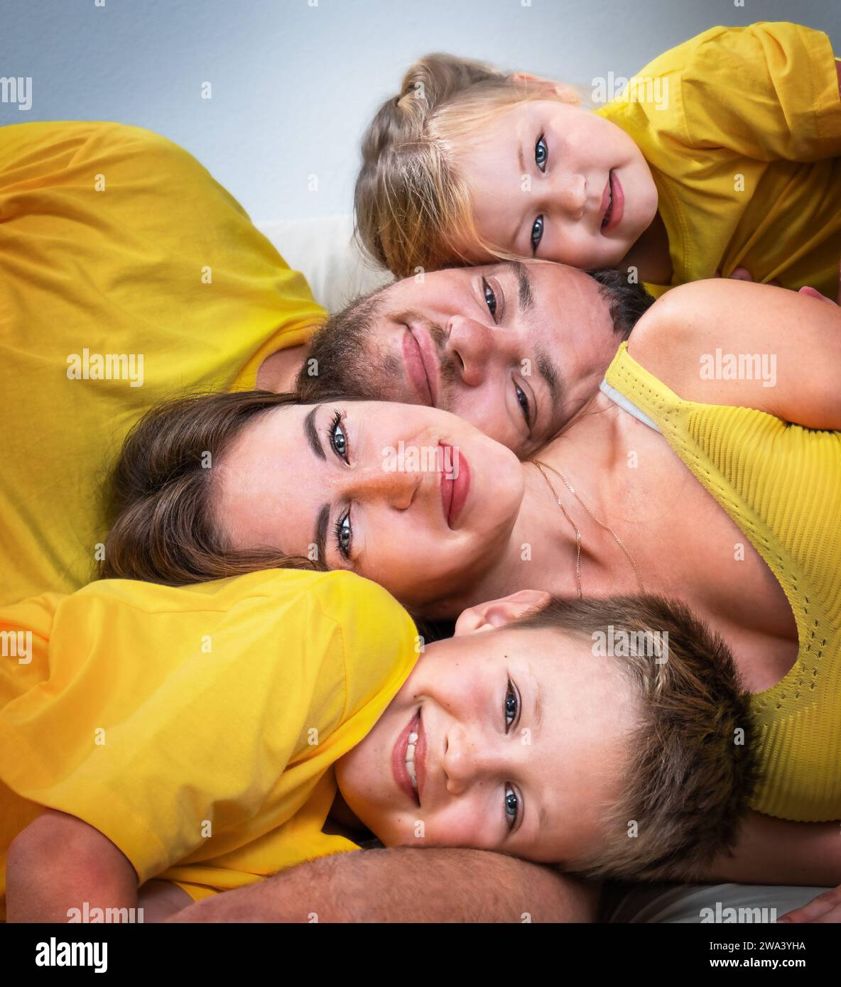 Portrait of a family together with their heads lying on top of each other Stock Photo