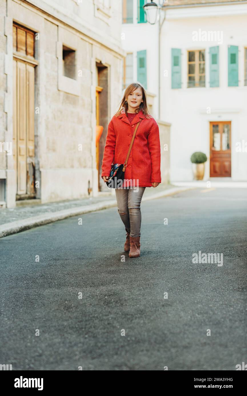 Outdoor portrait of cute teen girl wering red coat, fashion for children Stock Photo