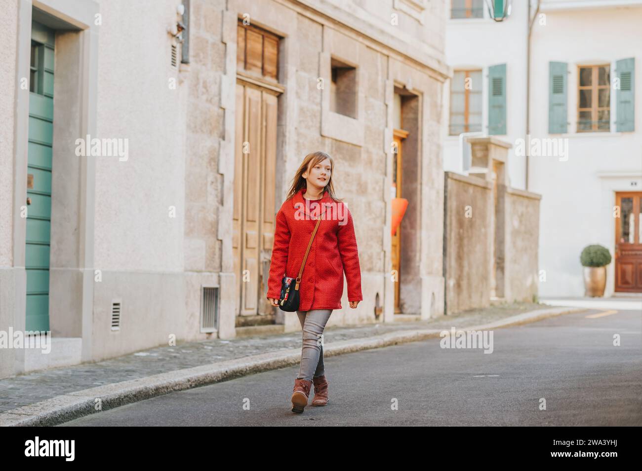 Outdoor portrait of cute teen girl wering red coat, fashion for children Stock Photo