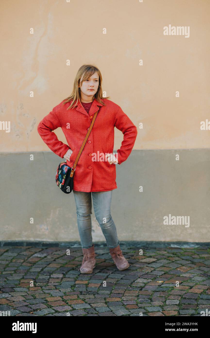 Outdoor portrait of cute teen girl wering red coat, fashion for children Stock Photo