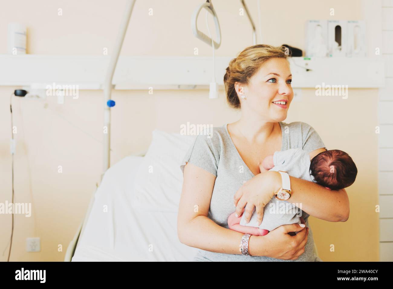 Happy young mother with newborn baby in hospital after giving birth