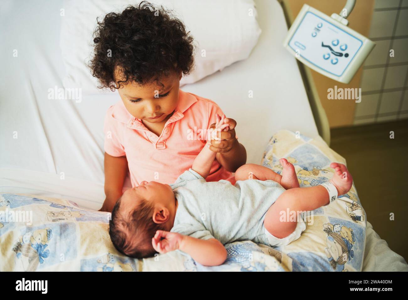 First meeting of adorable african toddler boy and his newborn brother in a prenatal hospital Stock Photo