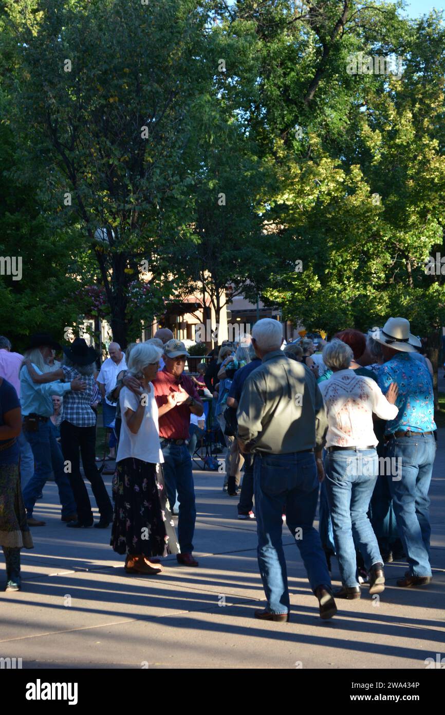 People in Cowboy hats dancing in the town square. Stock Photo