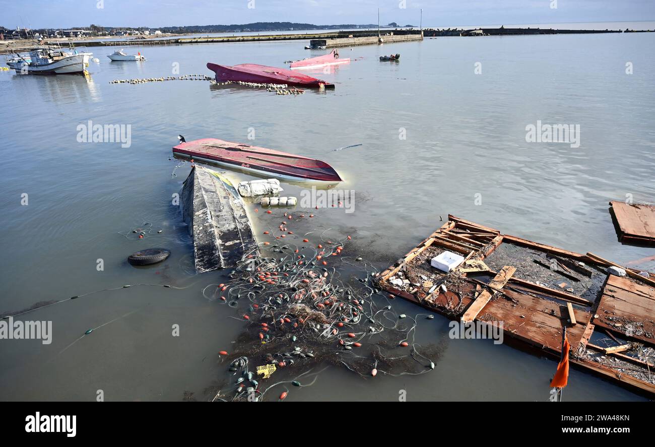 Fishery boats float upsidedown as a strong tsunami occurred in Suzu