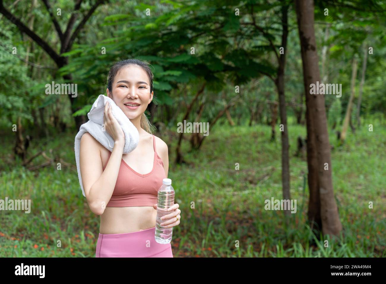 Young attractive Asian woman wiping off her sweat from her forehead