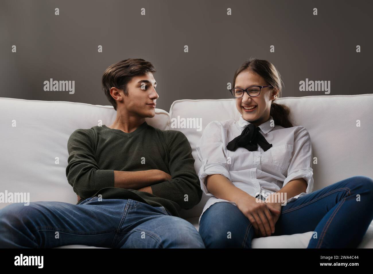 young man gazes at the woman with a look of amusement as she laughs ...